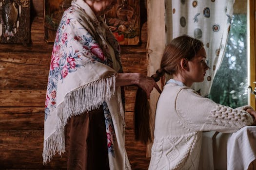 A grandmother lovingly braids her granddaughter's hair in a cozy, rustic room, capturing a heartwarming family moment.
